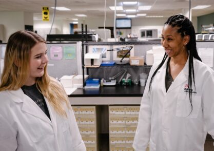 two lab technicians standing and talking in laboratory